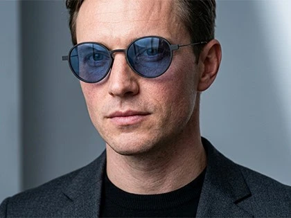 man wearing lightweight carbon fiber sunglasses with slim stainless steel temples and blue polarized lenses man wearing lightweight carbon fiber sunglasses with slim stainless steel temples and blue polarized lenses